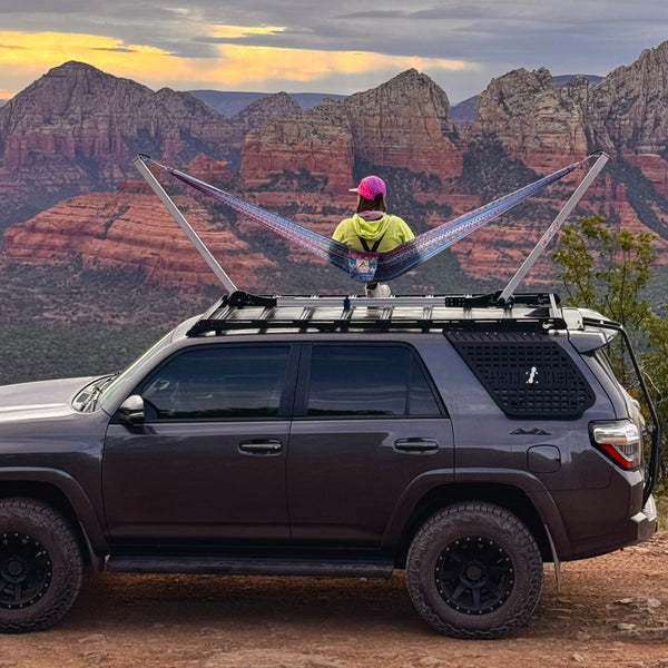 Woman sits in rooftop hammock overlooking epic canyon