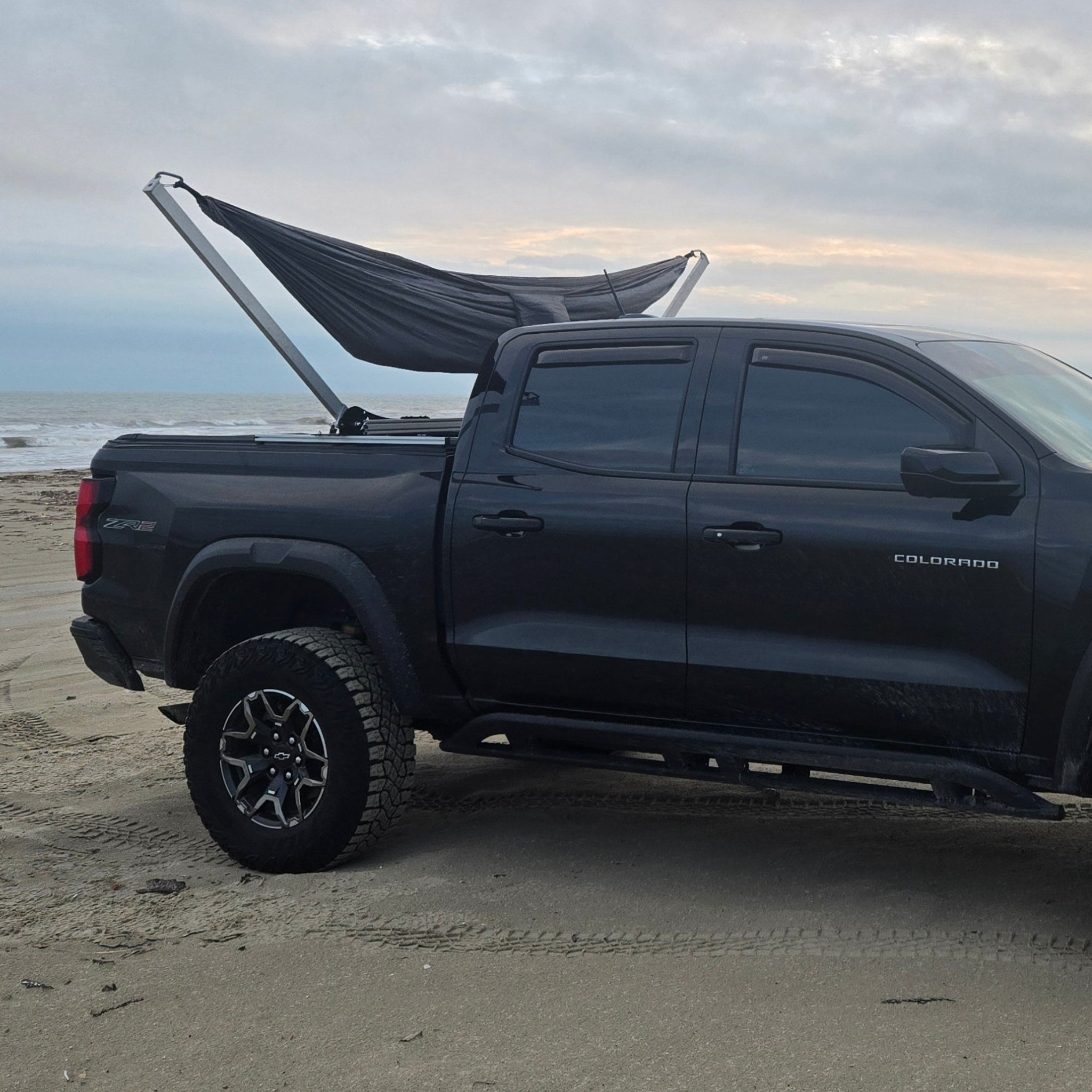 Summit Hammock Mount mounted to the truck bed rails of a Chevy Colorado parked on the beach.